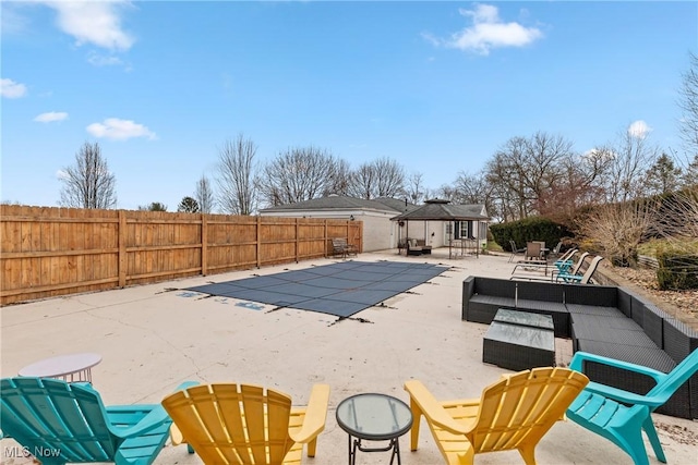 view of swimming pool featuring a patio, a fenced in pool, a fenced backyard, a gazebo, and outdoor lounge area