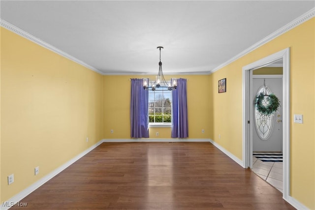 unfurnished dining area featuring a notable chandelier, crown molding, baseboards, and wood finished floors