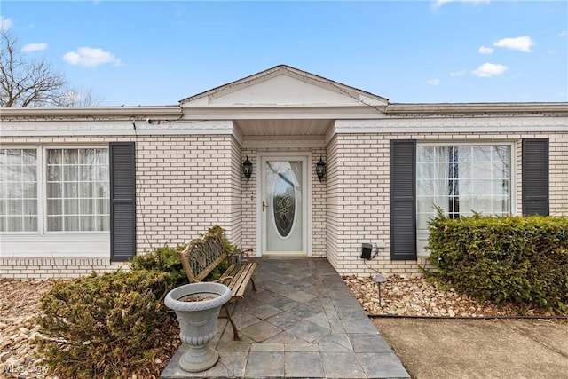 view of exterior entry with brick siding