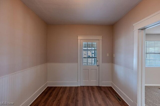 entryway featuring a wainscoted wall, plenty of natural light, dark wood-style floors, and visible vents