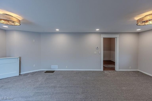 empty room with baseboards, carpet flooring, recessed lighting, and visible vents
