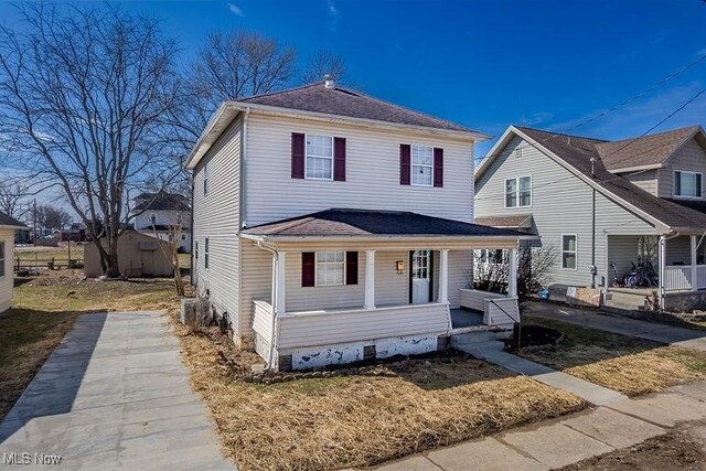 view of front of house featuring covered porch, an outbuilding, and a storage unit