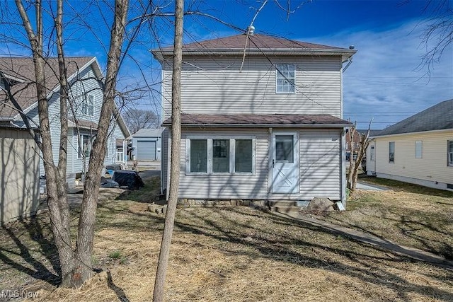 rear view of house with a lawn and entry steps
