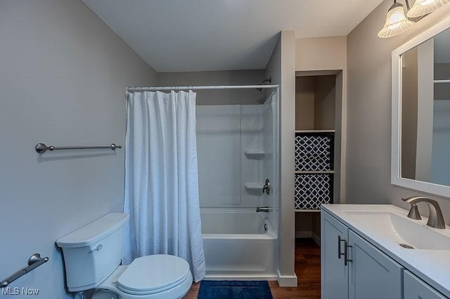 bathroom with vanity, wood finished floors, toilet, and shower / bath combo with shower curtain