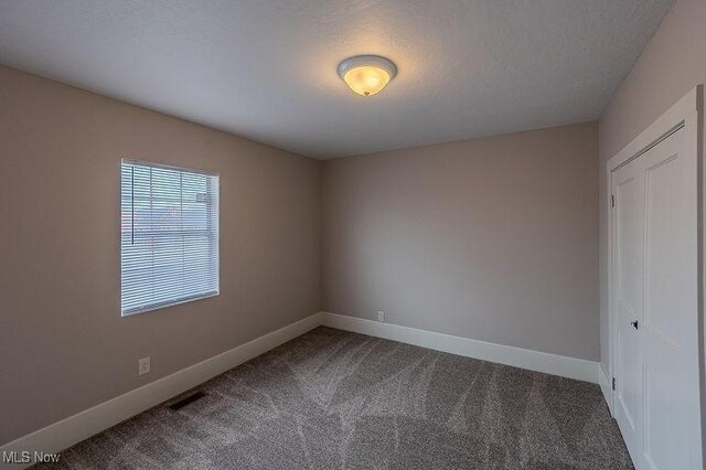 carpeted spare room with baseboards