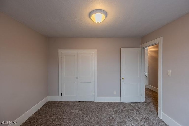 unfurnished bedroom with baseboards, carpet, and a closet