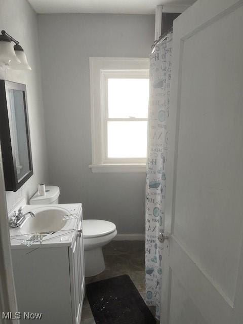 bathroom featuring vanity, toilet, a shower with curtain, and baseboards