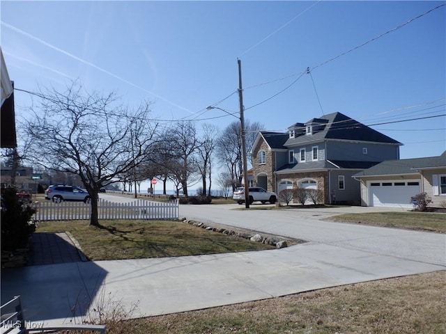 view of yard featuring fence, a garage, and driveway