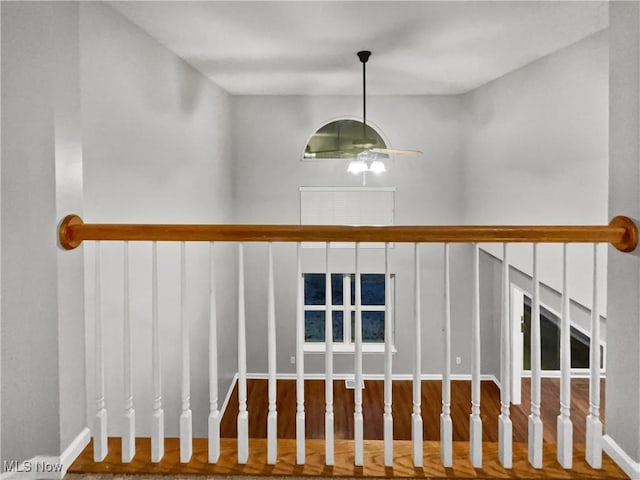 stairway featuring a ceiling fan and wood finished floors