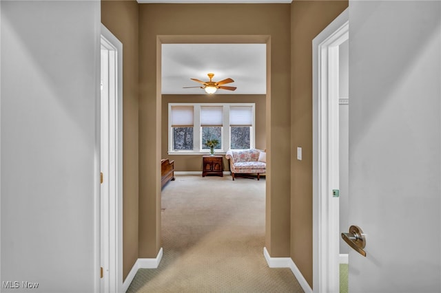 hall featuring light carpet and baseboards