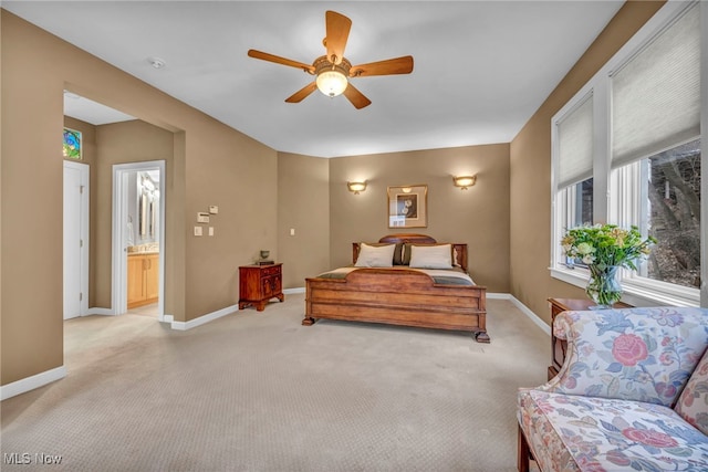 bedroom featuring light carpet, a ceiling fan, and baseboards