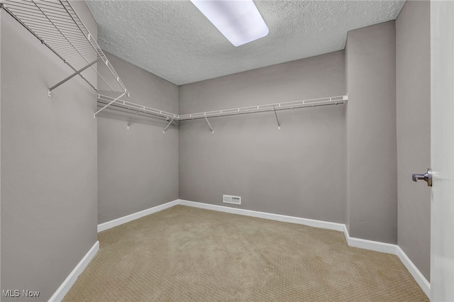 walk in closet featuring visible vents and carpet