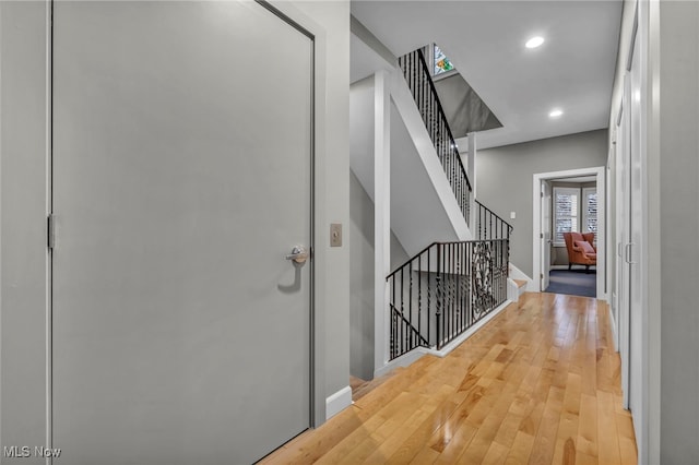 hall with recessed lighting, stairway, baseboards, and hardwood / wood-style floors