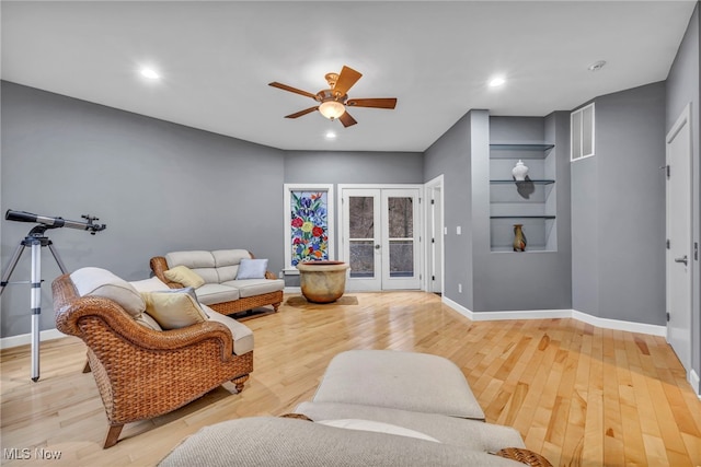 living area featuring light wood finished floors, french doors, and baseboards