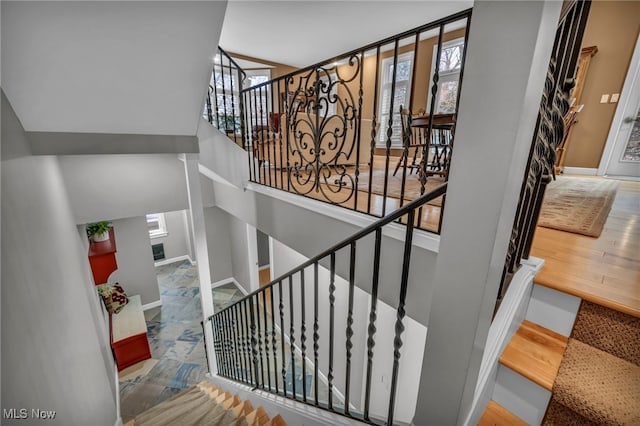 staircase with plenty of natural light and baseboards