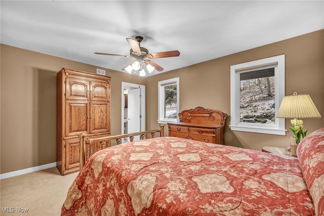 bedroom featuring light carpet, visible vents, a ceiling fan, and baseboards