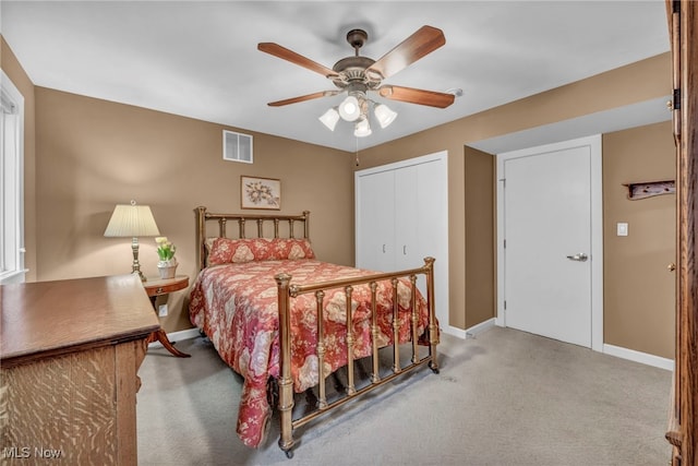 carpeted bedroom featuring visible vents, baseboards, a closet, and ceiling fan