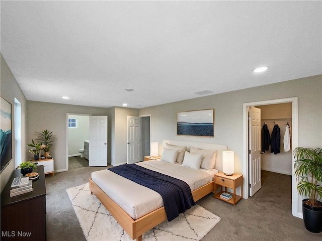 carpeted bedroom featuring a spacious closet, recessed lighting, connected bathroom, and baseboards