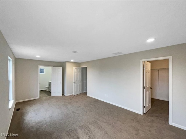 unfurnished bedroom with visible vents, baseboards, recessed lighting, a spacious closet, and carpet flooring