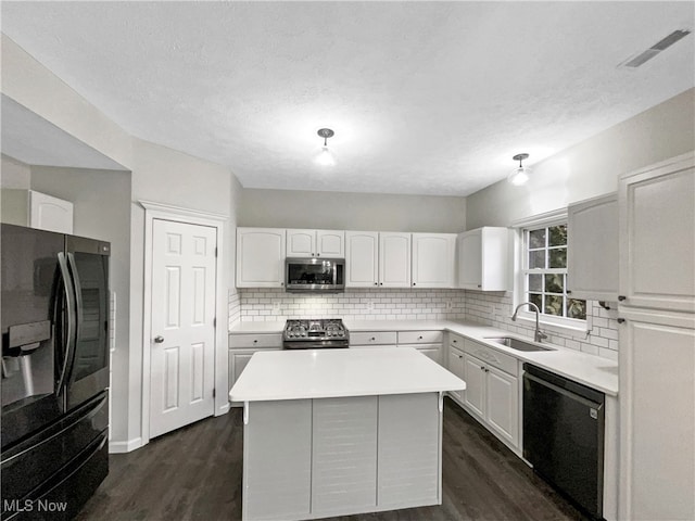 kitchen with visible vents, black appliances, a sink, tasteful backsplash, and white cabinetry