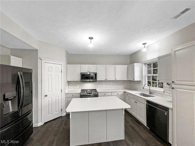 kitchen with visible vents, a sink, black appliances, white cabinets, and tasteful backsplash