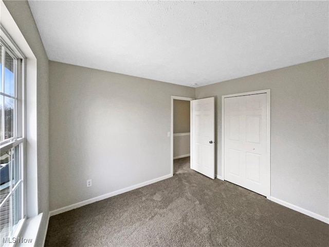 unfurnished bedroom featuring a closet, baseboards, and carpet flooring