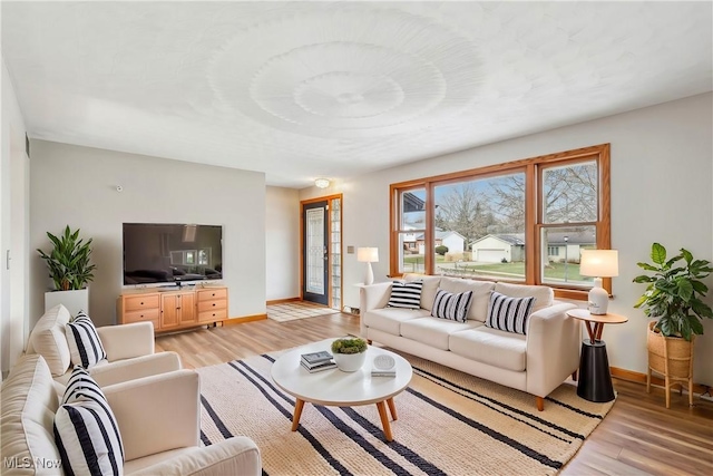 living room with light wood-type flooring and baseboards