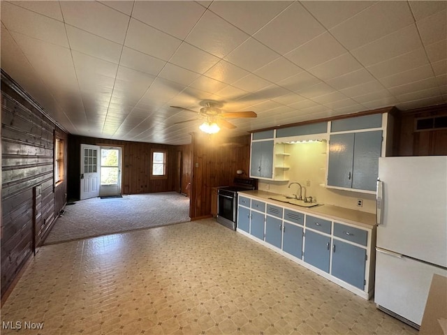 kitchen featuring visible vents, stainless steel range with electric stovetop, open shelves, a sink, and freestanding refrigerator