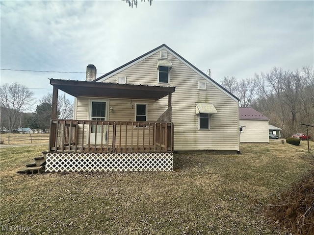 rear view of house with a wooden deck and a chimney