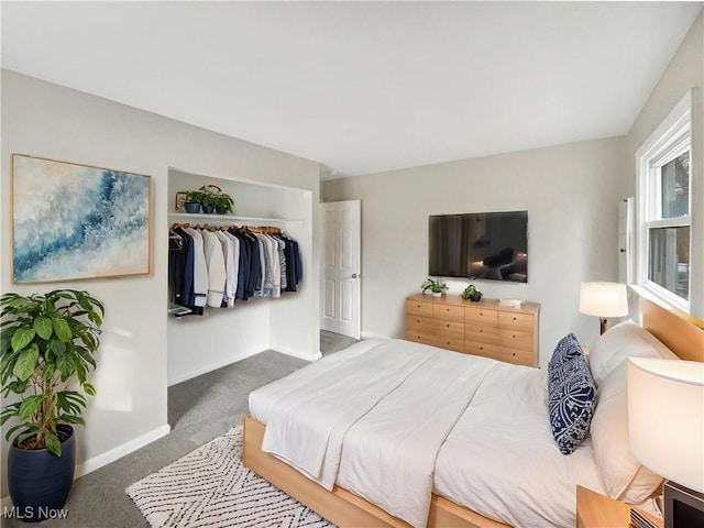 carpeted bedroom with a closet and baseboards