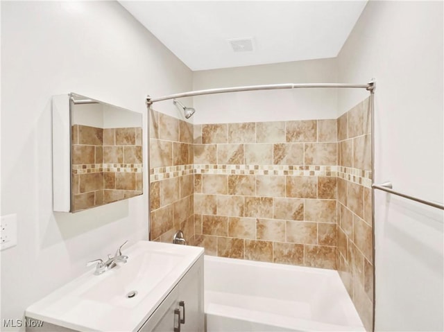 bathroom featuring visible vents, tub / shower combination, and vanity