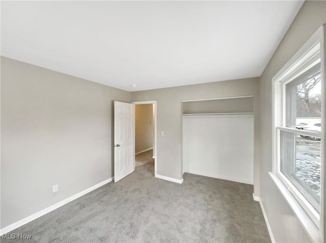 unfurnished bedroom with a closet, baseboards, and carpet