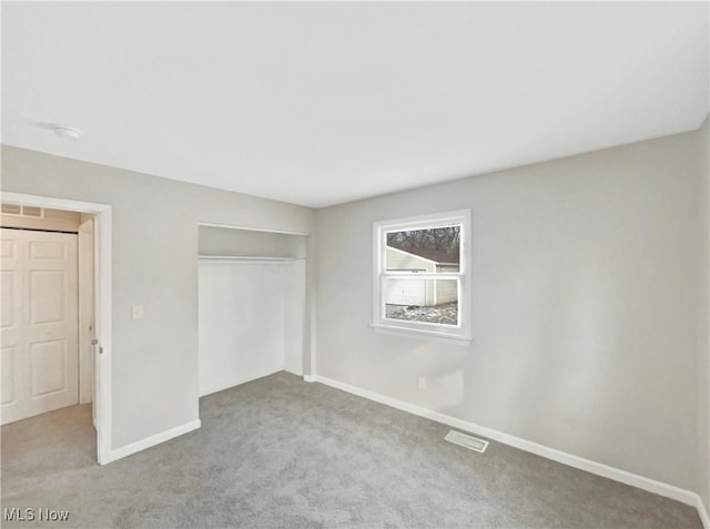 unfurnished bedroom featuring a closet, visible vents, baseboards, and carpet floors