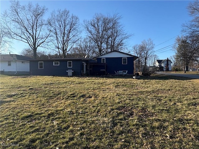 rear view of house featuring a yard