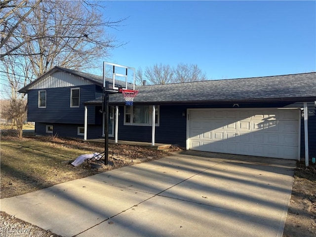 tri-level home with driveway, a shingled roof, and a garage