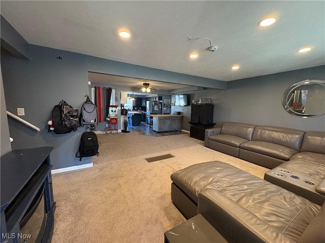 living area with a textured ceiling, recessed lighting, carpet flooring, baseboards, and ceiling fan