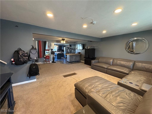 living room with recessed lighting, baseboards, carpet floors, and a textured ceiling