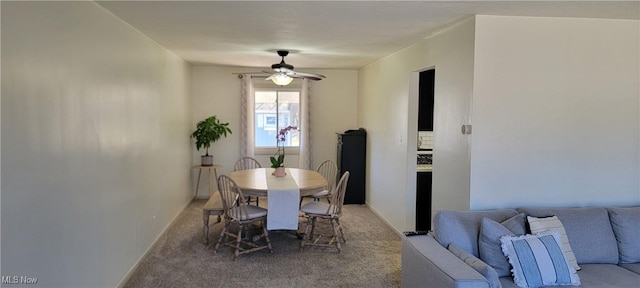 carpeted dining area with baseboards and a ceiling fan