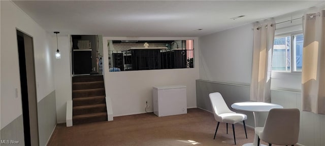 carpeted dining area featuring stairs, baseboards, and visible vents