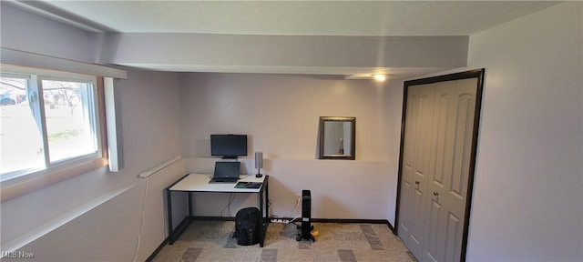 office space featuring baseboards and light carpet