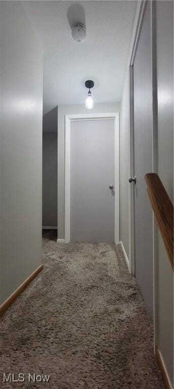 hall featuring baseboards and carpet floors