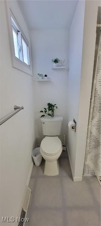 bathroom with toilet, visible vents, and baseboards