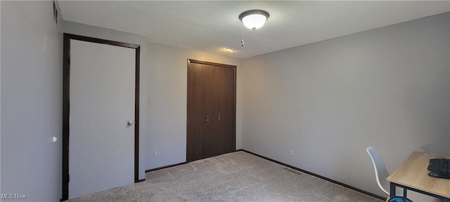 unfurnished bedroom featuring visible vents, a textured ceiling, a closet, carpet flooring, and baseboards