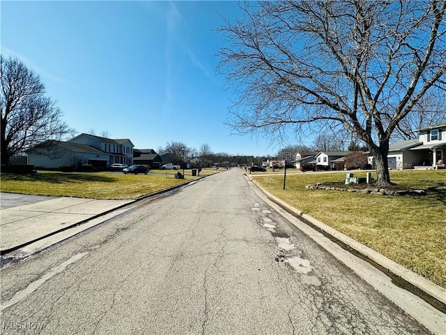 view of road with a residential view and curbs