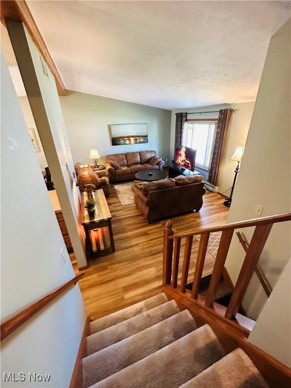 staircase featuring lofted ceiling and wood finished floors