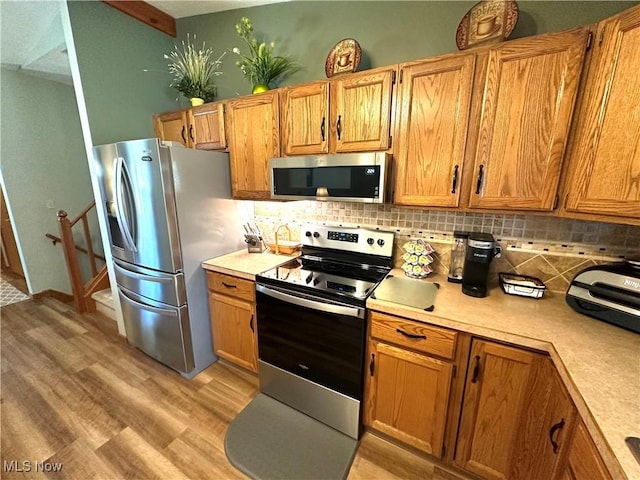 kitchen featuring decorative backsplash, appliances with stainless steel finishes, and light countertops