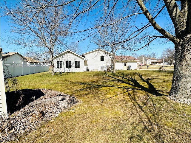 back of property featuring a lawn and fence