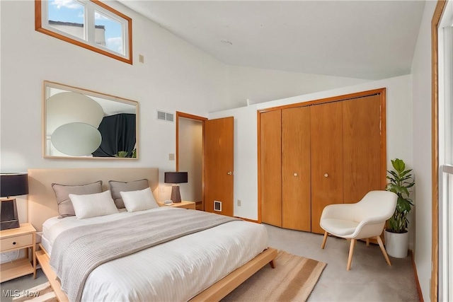 carpeted bedroom featuring visible vents, lofted ceiling, and a closet