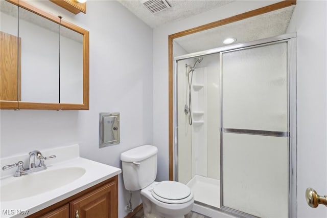 full bath with vanity, visible vents, a stall shower, a textured ceiling, and toilet