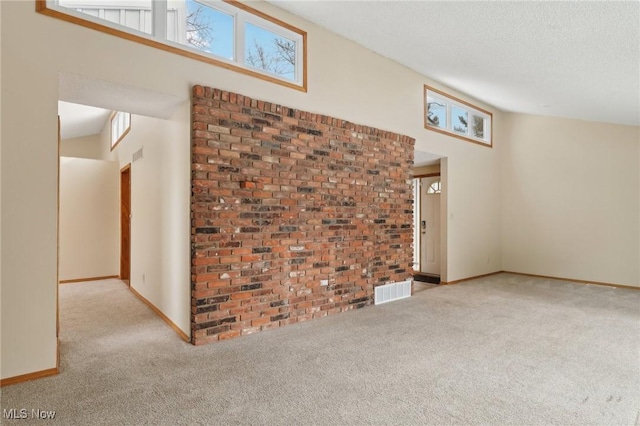 unfurnished living room featuring baseboards, visible vents, carpet floors, and a textured ceiling